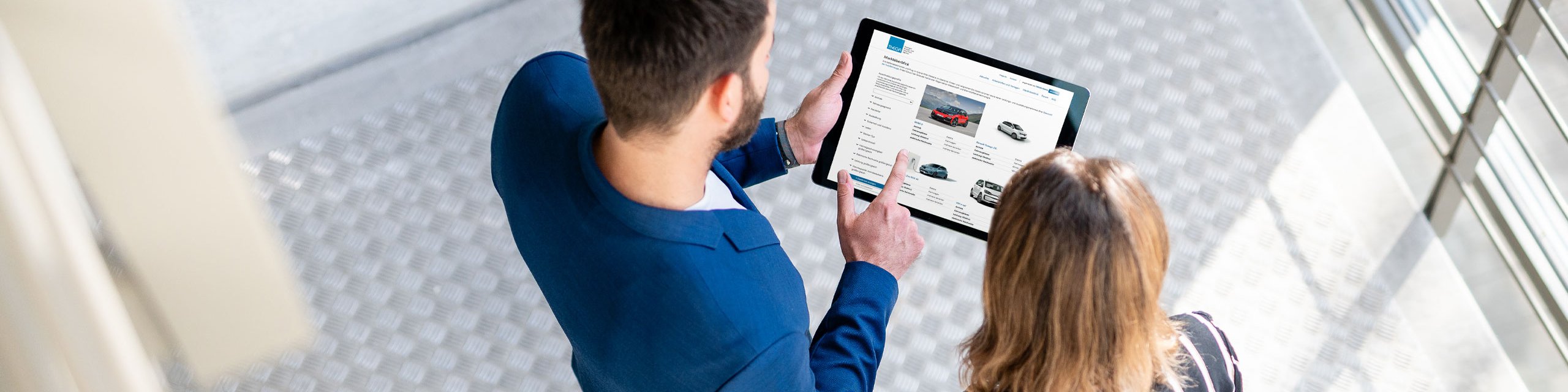 Online-Tool Mobilitätskompass Ein Mann und eine Frau schauen auf ein Tablet mit dem Mobilitätskompass auf dem Bildschirm