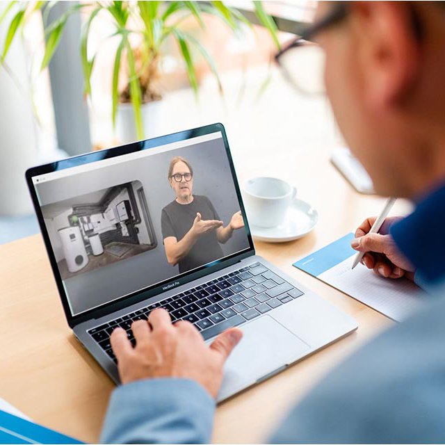 Mann schaut auf Laptop mit dem Wissensportal Wärmepumpe Mann mit Brille arbeitet an einem Laptop, auf dem das Wissensportal Wärmepumpe zu sehen ist