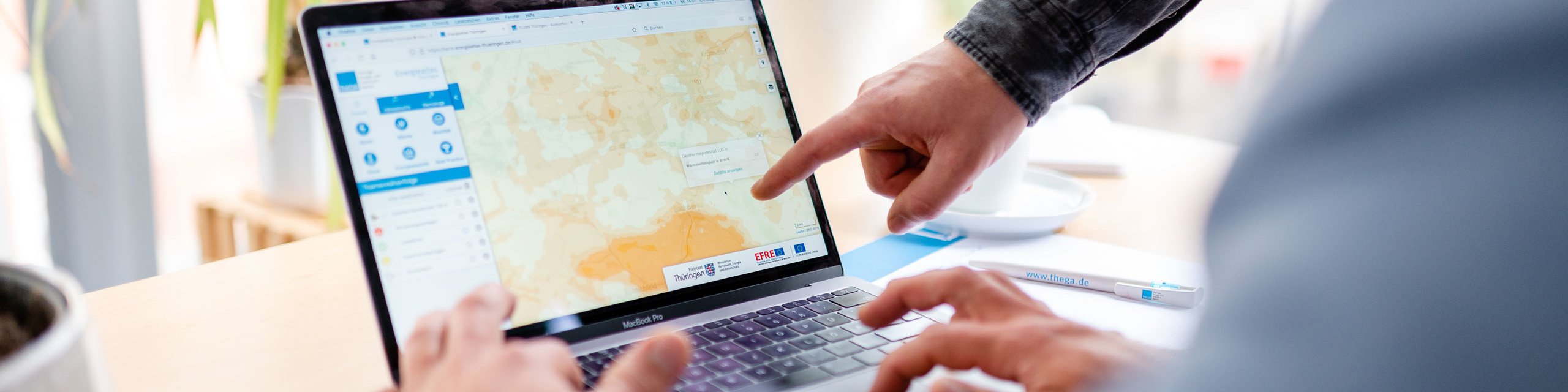 Zwei Personen betrachten den Energieatlas Thüringen auf einem Laptopbildschirm
