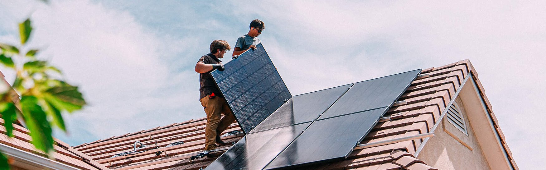Zwei Männer bauen PV-Paneele auf ein Dach