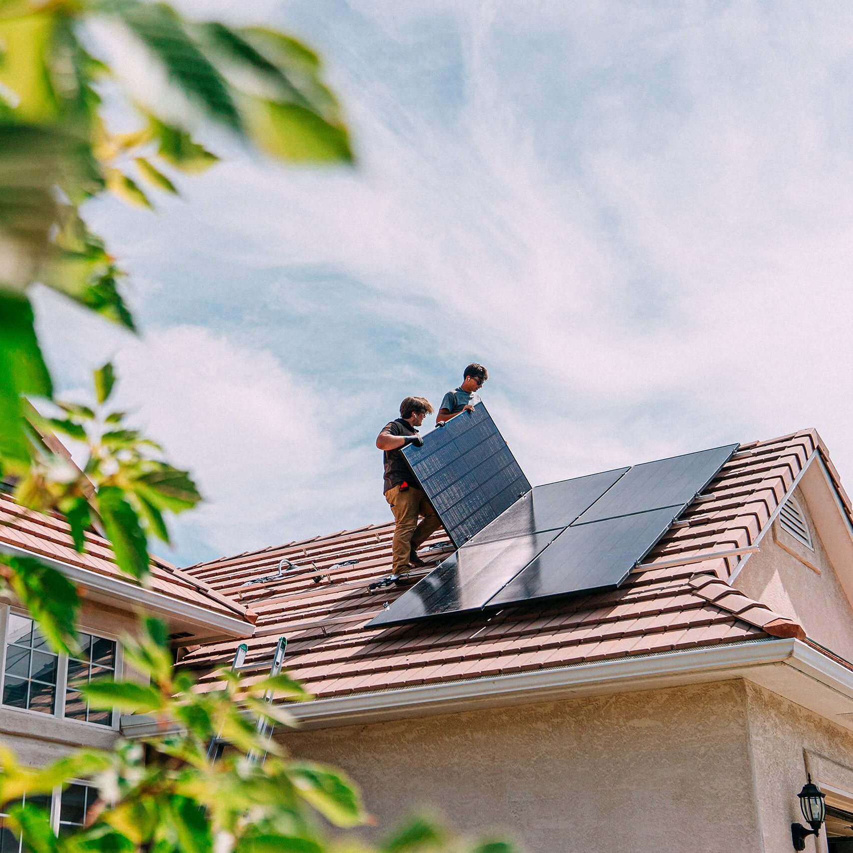 Männer bauen PV-Paneele auf Dach Zwei Männer bauen PV-Paneele auf ein Dach