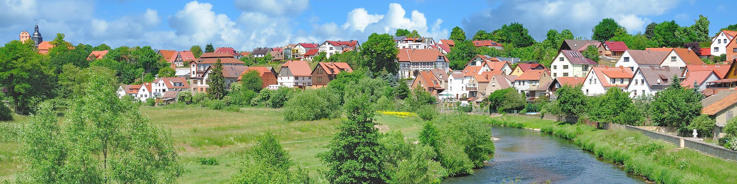 Blick auf den Fluss Werra mit der Stadt Breitungen im Hintergrund