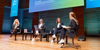 Podiumsdiskussion auf der REKON 2025 in der Weimarhalle, mit Caro Matzko als Moderatorin und drei weiteren Rednerinnen. Alle sitzen auf Stühlen