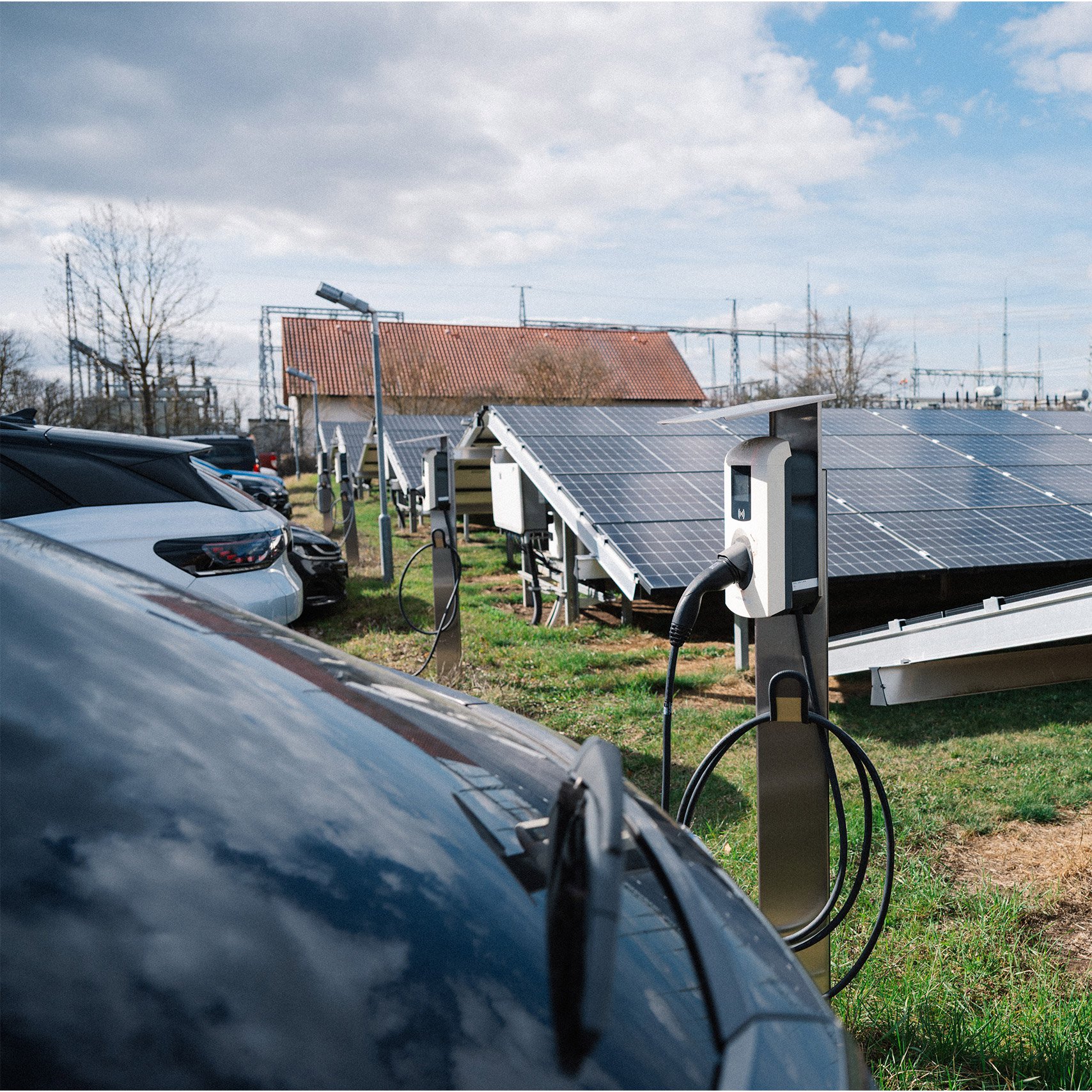 Mehrere E-Autos laden auf einem Firmenparkplatz in Arnstadt vor einer Freiflächensolaranlage