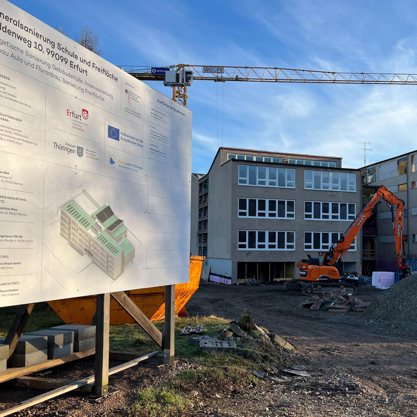 Baufällige Schule in Erfurt mit Bagger und Bauplakat Schulgebäude mit Bagger und Baustellenplakat