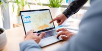Mann sitzt vor einem Laptop und bekommt von einer anderen Person den Energieatlas der Landesenergieagentur Thüringen (ThEGA) erklärt