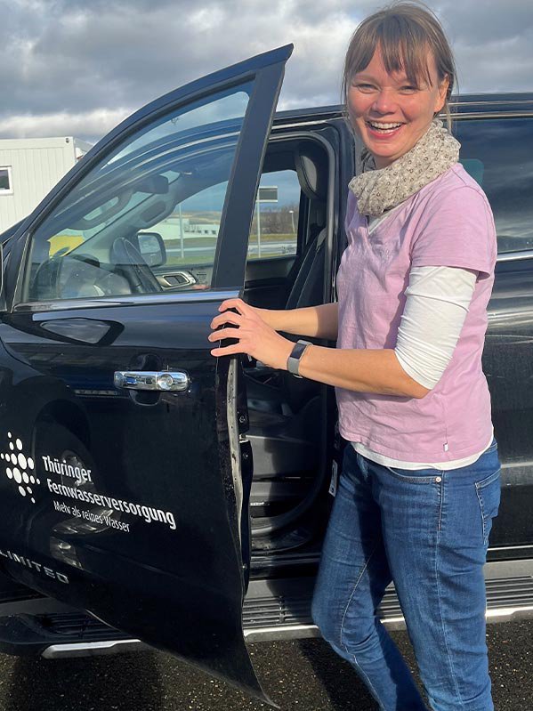 Verena Hanstein von der Thüringer Fernwasserversorgung steht vor einem Auto