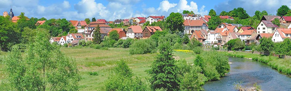 Blick auf den Fluss Werra mit der Stadt Breitungen im Hintergrund