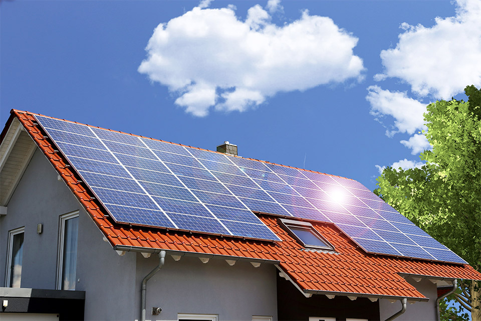 Sonne spiegelt sich auf der Solaranalge auf dem Dach eines Einfamilienhauses