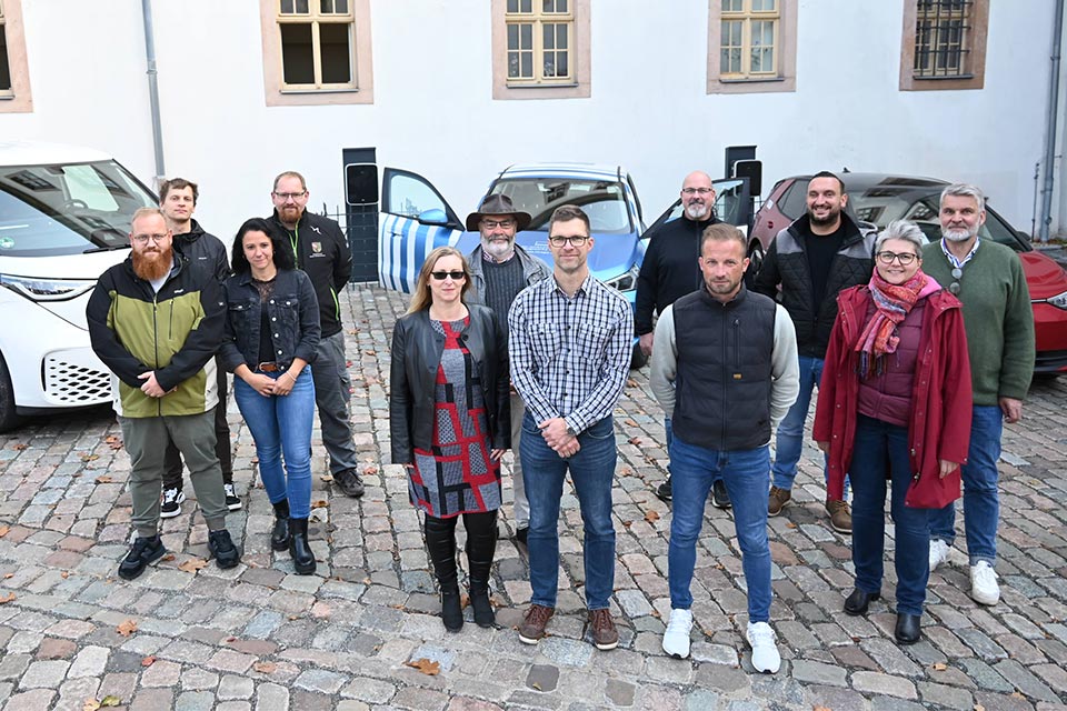 Teaser E-Lotsen Kursteilnehmer Zwölf E-Lotsen aus Ostthüringen stehen vor drei Elektroautos